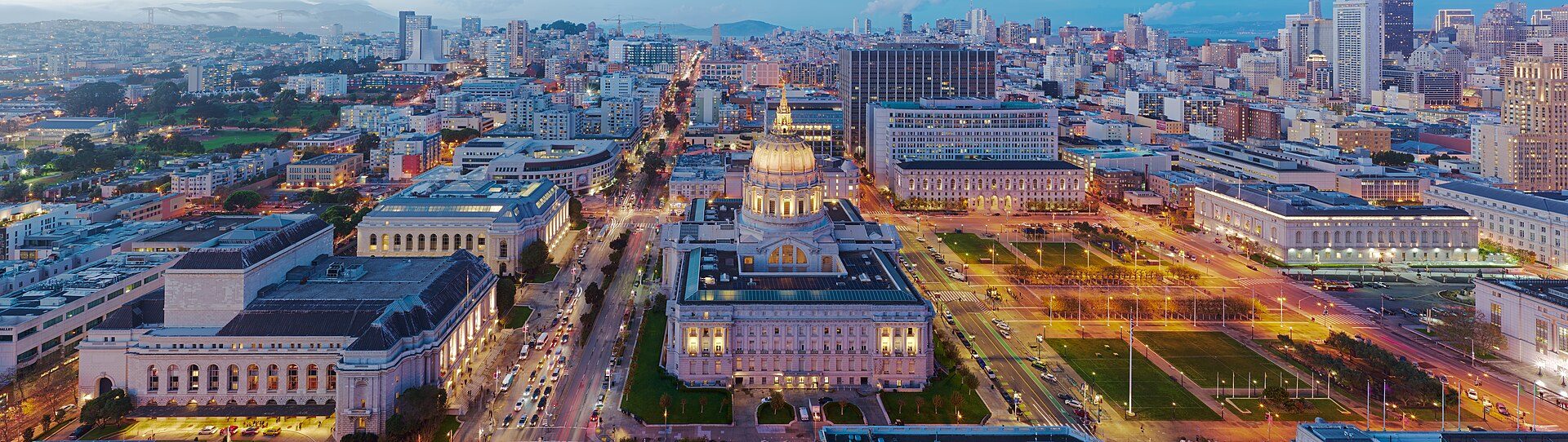 San Francisco City Hall glowing gold against the dusk sky