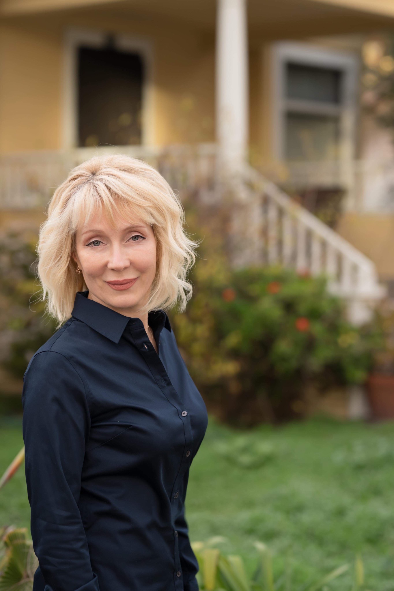 Elena Wyman in front of a client's home
